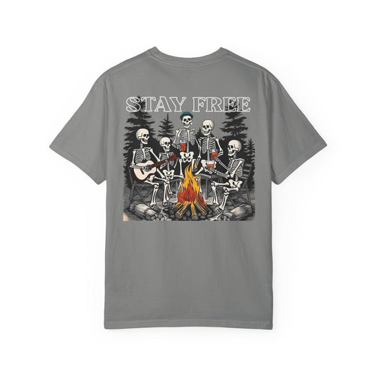 Gray t-shirt with skeletons around a campfire graphic and 'Stay Free' text on a white background
